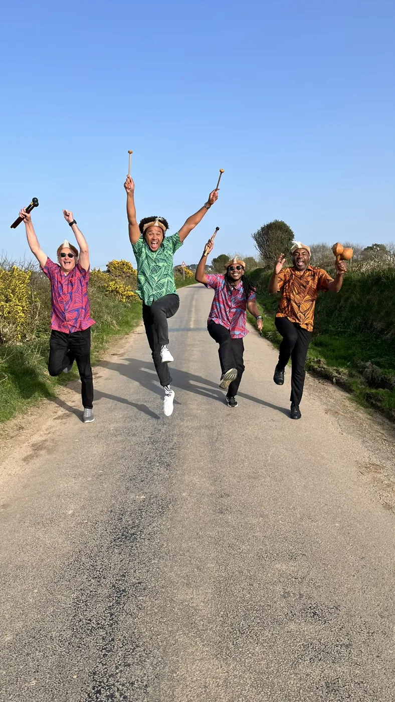 The four members of Otto and the Mutapa Calling jumping in the air on a country lane