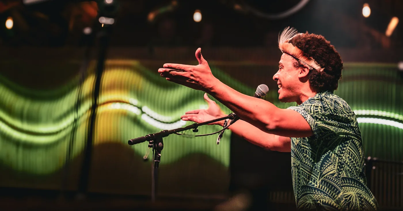 A member of Otto and the Mutapa Calling singing on stage with arms outstretched